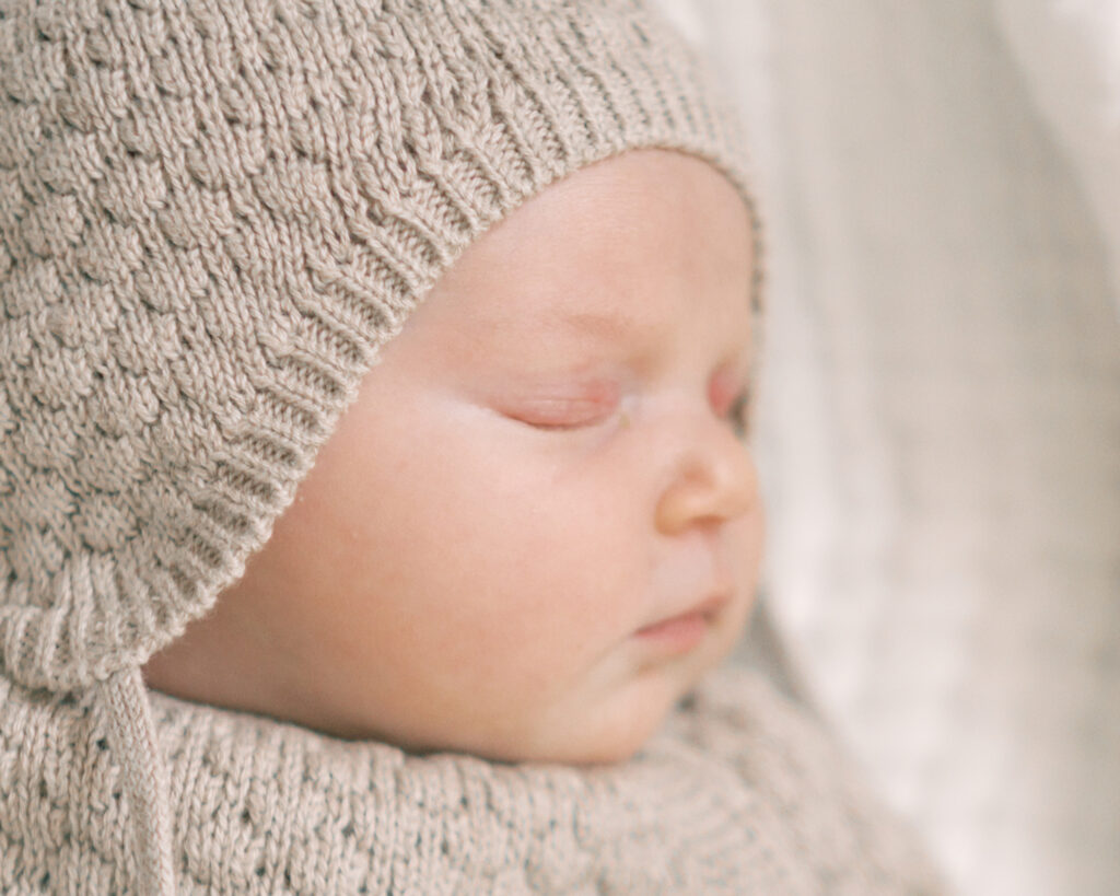 Close up portrait of a newborn baby while she sleeps during her Oklahoma Newborn Photo Session with by Courtney Cronin Photography