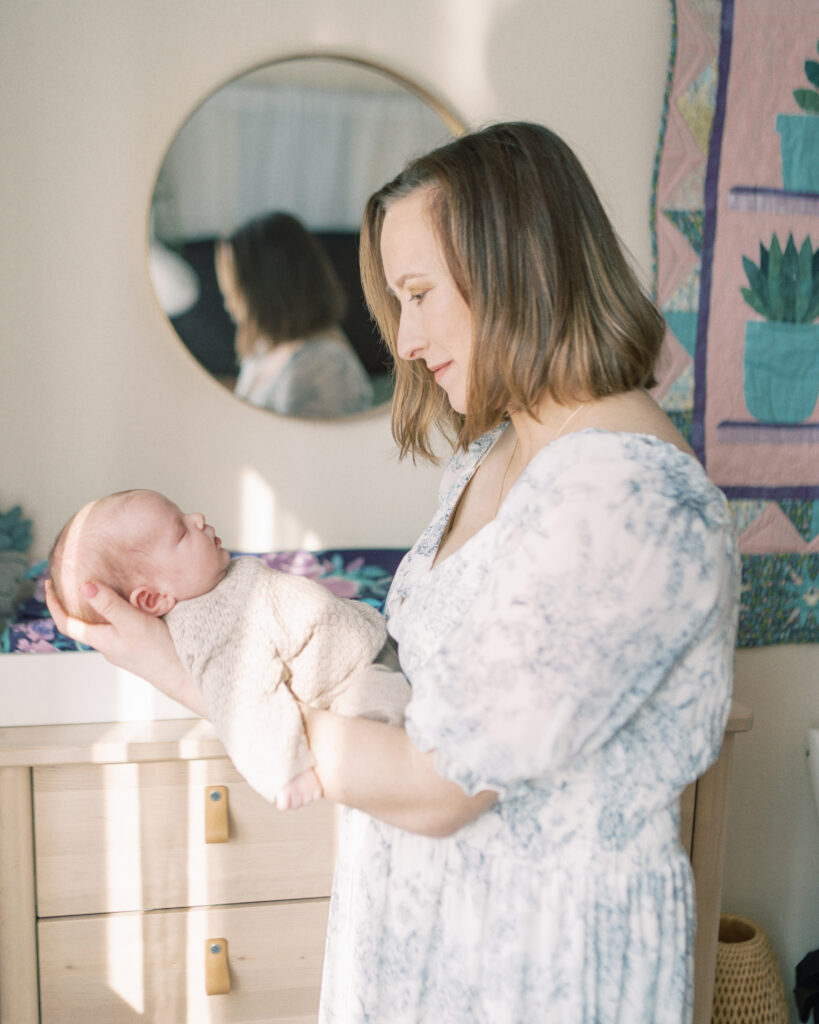Mother lovingly gazing at her newborn daughter during her newborn photo session by Oklahoma newborn photographer by Courtney Cronin