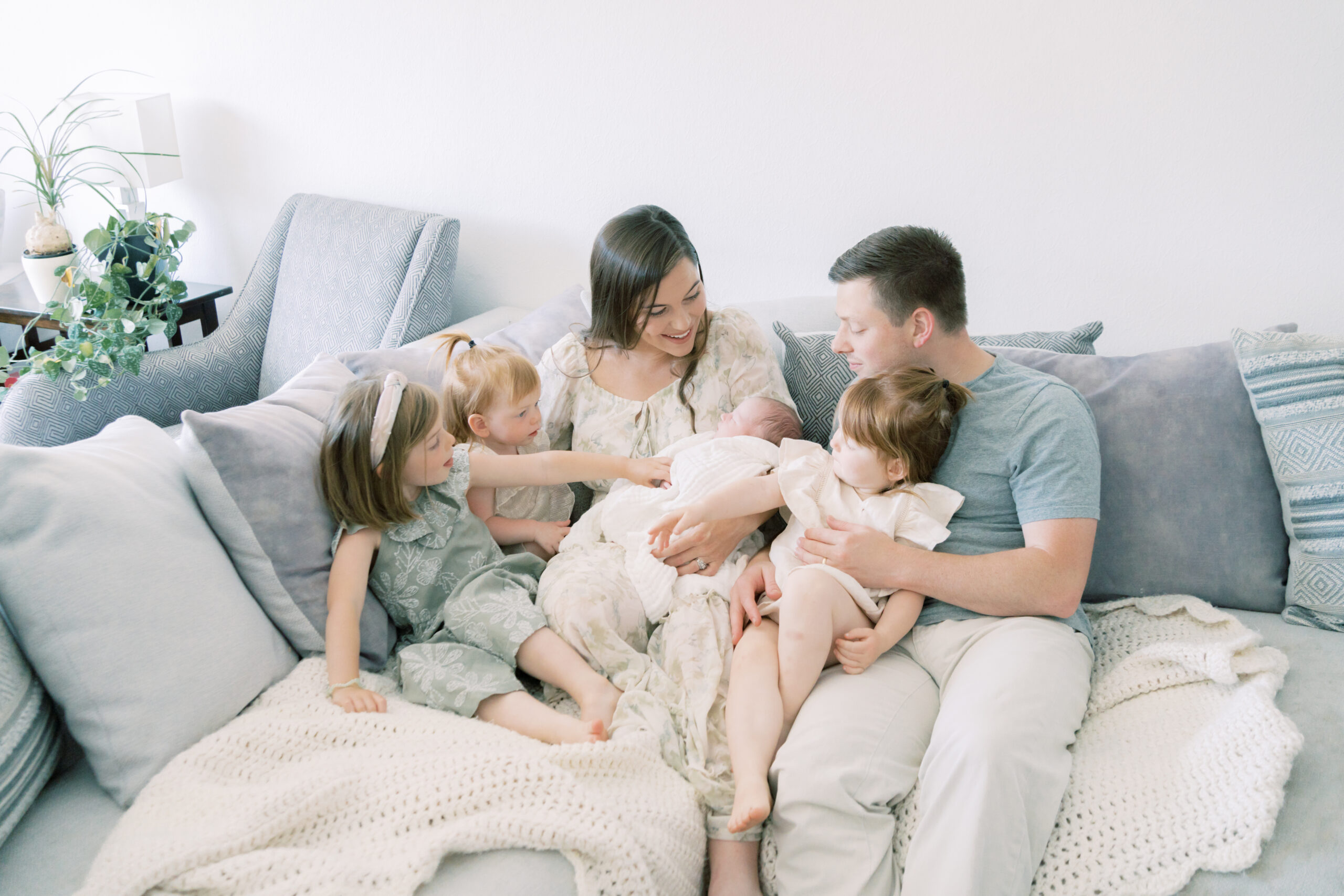 Family of 6 snuggles on the couch together during their newborn photo session by Lawton Ok Photographer Courtney Cronin