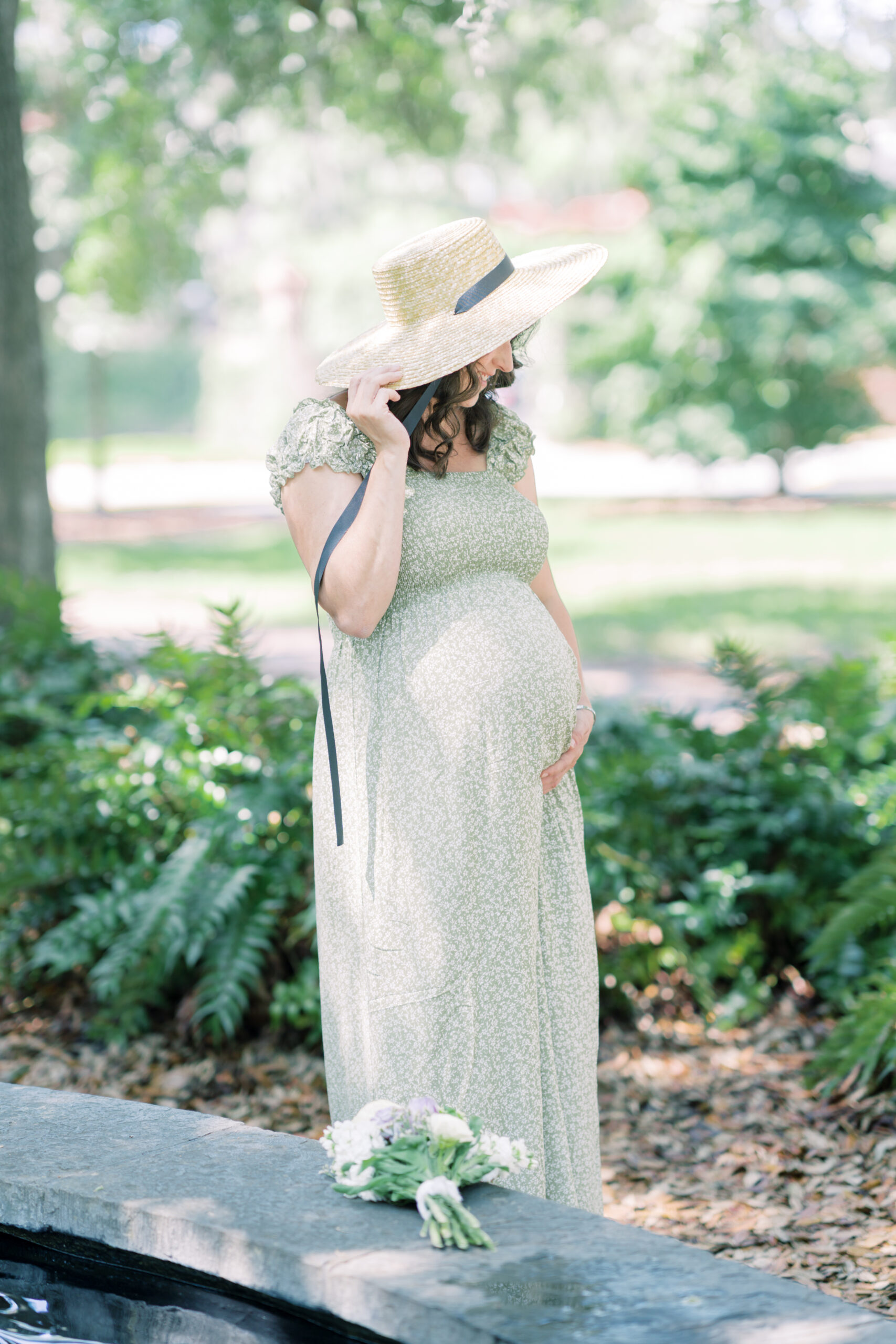 Pregnant mother holding sun hat